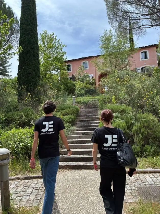 Two members of Junior Enterprises in JE T-shirts climb a stone staircase in the gardens of the estate that hosted the congress.