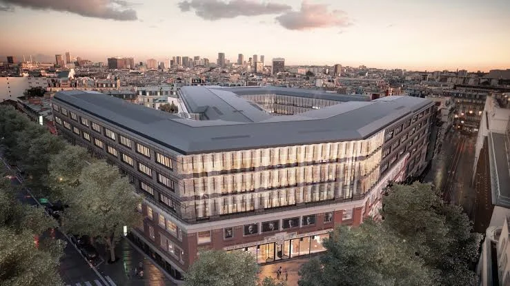 Vue aérienne en perspective du futur campus de l’ESPCI : un bâtiment d’angle aux façades vitrées, en plein Paris.